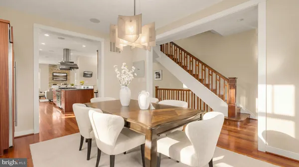 a view of a dining room with furniture a rug and wooden floor