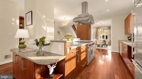 a kitchen with stainless steel appliances a table chairs in it and wooden floors