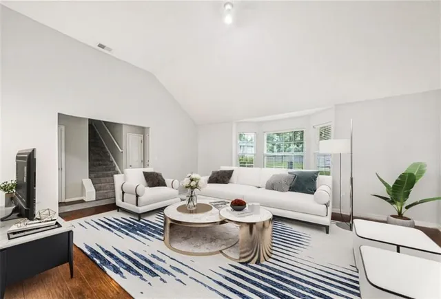 a living room with furniture a flat screen tv and a large window
