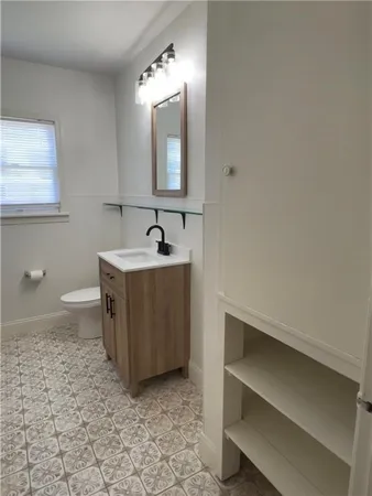 a view of an empty room with wooden floor and a ceiling fan