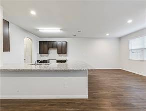 968 Rice Drive Bryan, TX 77803 - Photo 4 of 12 a view of a kitchen with kitchen island a sink wooden floor and window