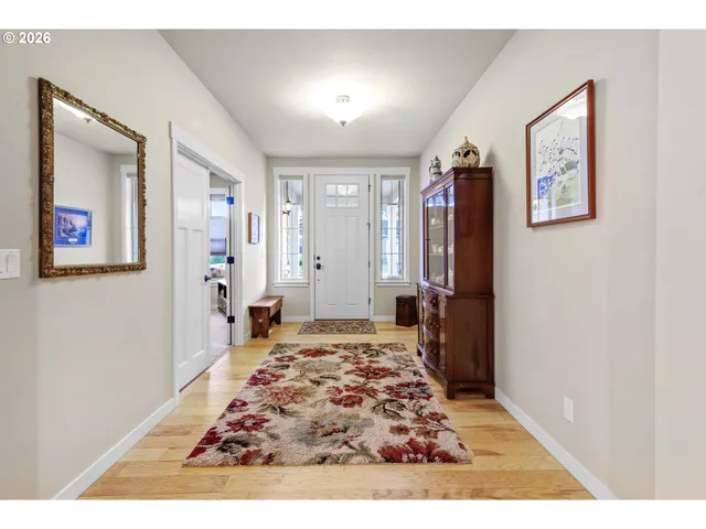 a view of a hallway with wooden floor and windows