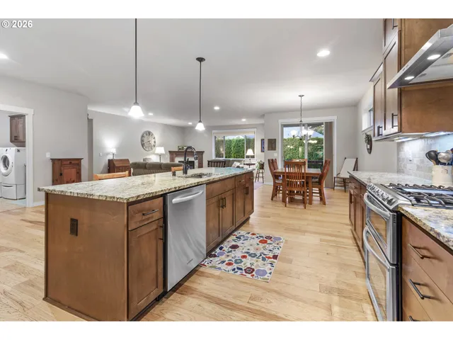a kitchen with stainless steel appliances granite countertop a sink stove and refrigerator