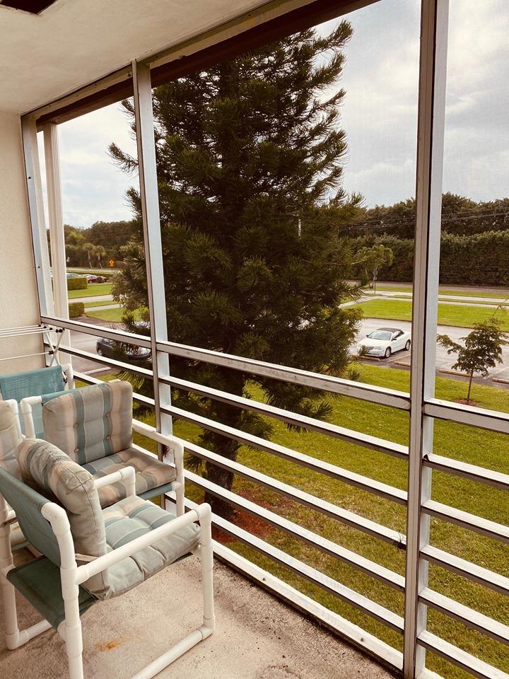 199 Fanshaw East, Unit 199 Boca Raton, FL 33434 - Photo 7 of 7 a view of a room with a large window and wooden floor
