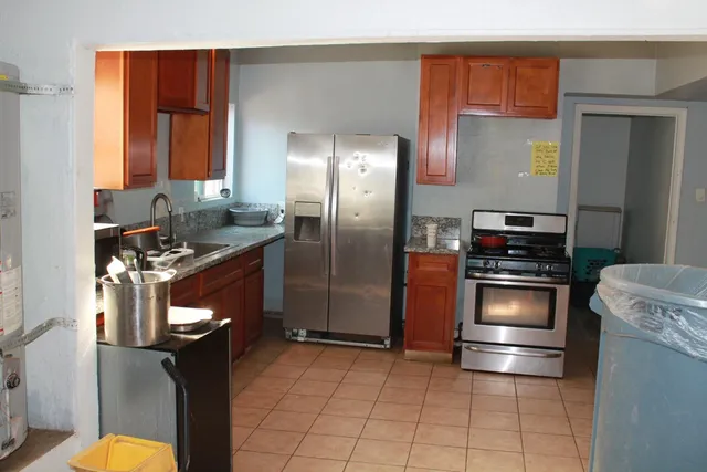a kitchen with granite countertop a refrigerator stove and sink