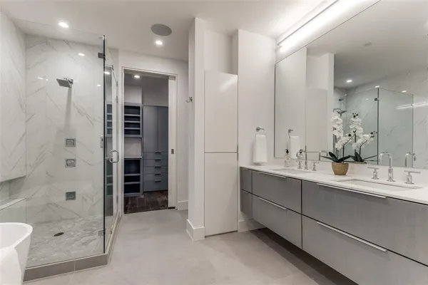 a bathroom with a double vanity sink mirror and shower