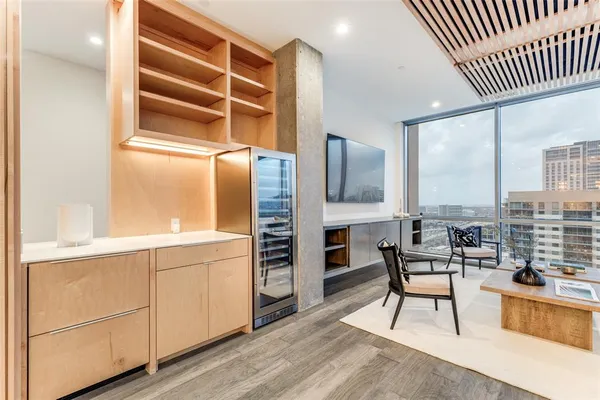 a kitchen with stainless steel appliances wooden floor and a view of living room