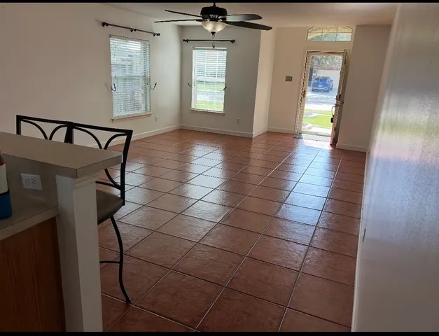 a view of a hallway with wooden floor and a bathroom