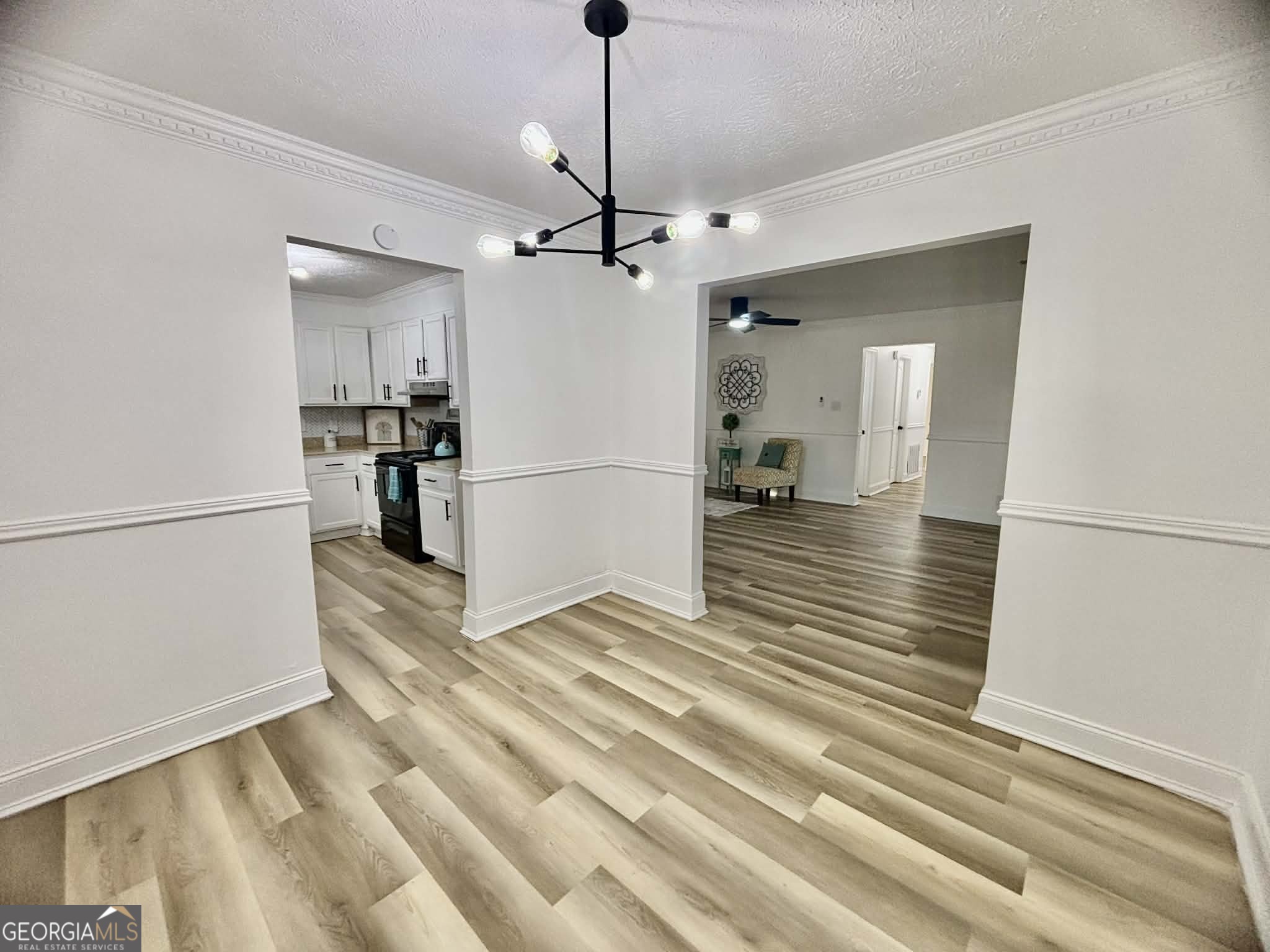 2800 South Estates Road Macon, GA 31216 - Photo 17 of 27 a view of a livingroom with wooden floor a ceiling fan and kitchen space