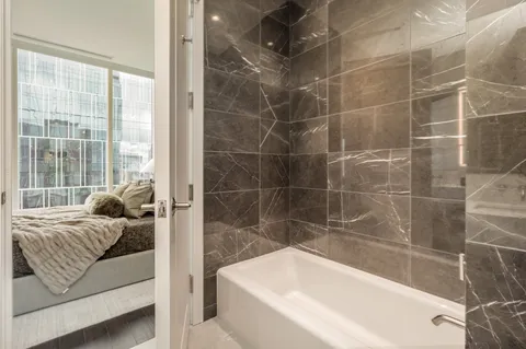 a bathroom with a bathtub and next to a window