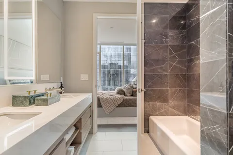 a bathroom with a tub sink and mirror