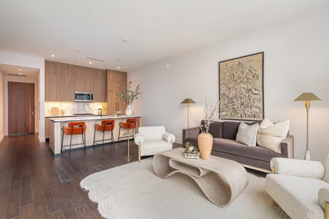 a living room with furniture and kitchen view