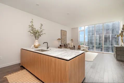 a kitchen with sink and view of living room