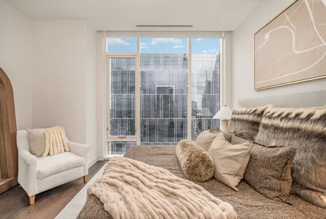 a bedroom with a bed and a couch next to a window