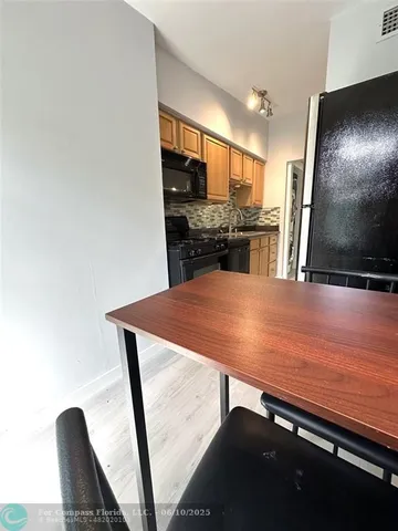 a view of a kitchen with kitchen island a counter top space and stainless steel appliances