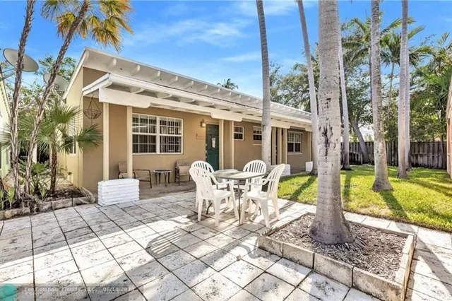 a view of a patio with table and chairs potted plants and palm tree