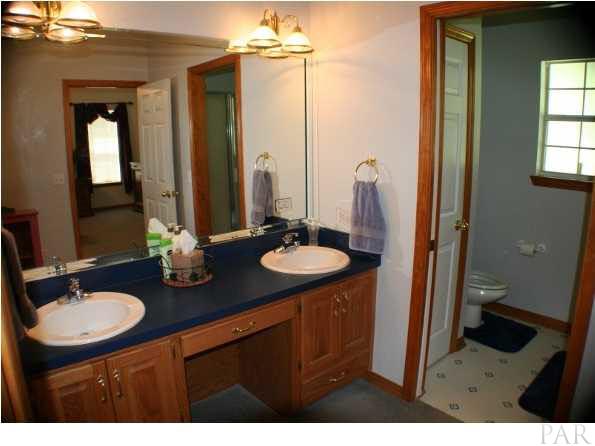 6012 Saddle Club Road Pace, FL 32571 - Photo 14 of 24 Master bath has double vanity and make-up station, large WALK IN closet to the left with pocket door. Water closet and shower room to the right.