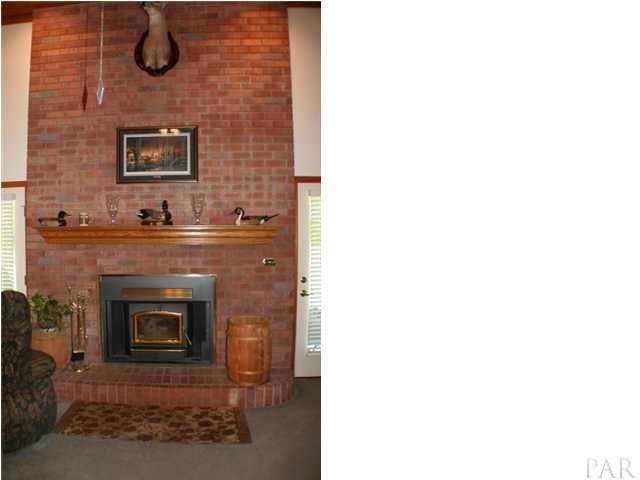 6012 Saddle Club Road Pace, FL 32571 - Photo 4 of 24 Two story brick hearth featuring a BUCK STOVE and custom OAK MANTLE.