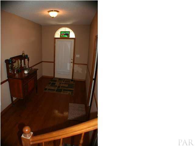 6012 Saddle Club Road Pace, FL 32571 - Photo 5 of 24 Foyer has gleaming hardwood floors ~ Study (possible 4th bedroom) to the right.