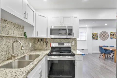 a kitchen with stainless steel appliances granite countertop a sink stove and cabinets