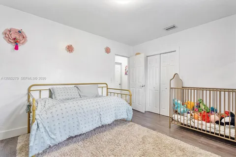 a bed room with furniture and baby crib