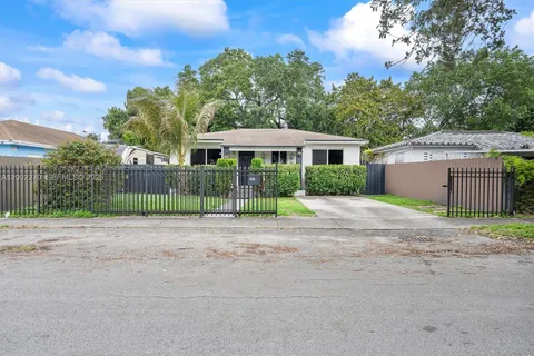 front view of a house with a yard and potted plants