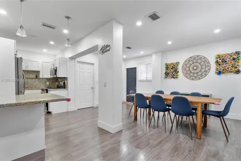 a view of kitchen with stainless steel appliances refrigerator dining table and chairs