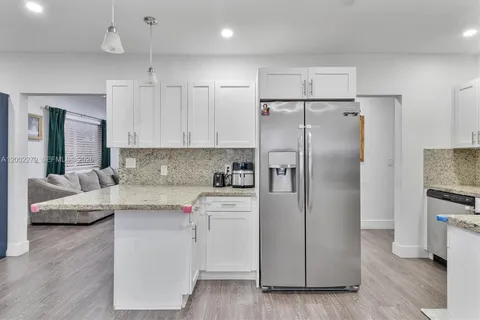 a kitchen with a refrigerator sink and cabinets