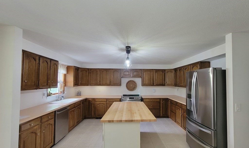 9 David Drive Pelham, NH 03076 - Photo 7 of 42 a kitchen with stainless steel appliances granite countertop a sink refrigerator and cabinets