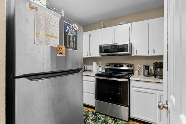 a kitchen with stainless steel appliances a stove a microwave and a refrigerator