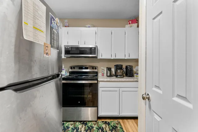 a kitchen with stainless steel appliances granite countertop a stove a refrigerator and a microwave