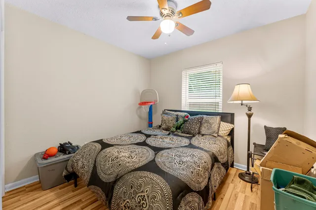 a bedroom with a bed and wooden floor
