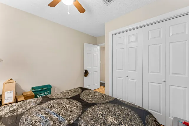 a bedroom with a bed and a ceiling fan