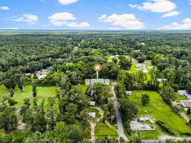 a view of a green yard with large trees