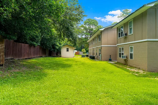 a view of a backyard with plants and wooden fence