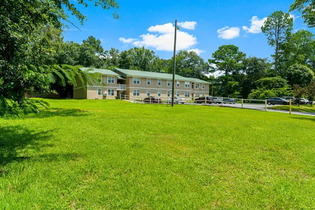 an aerial view of a tennis ground and a cars park side of the road