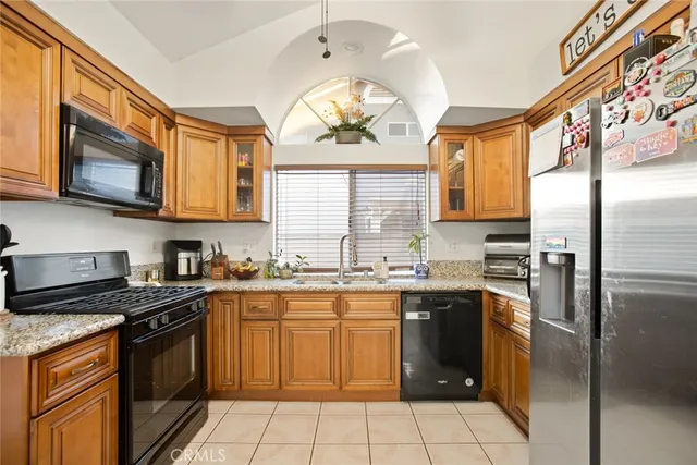 a kitchen with stainless steel appliances granite countertop a stove top oven a sink dishwasher and a microwave oven on the blue kitchen countertops