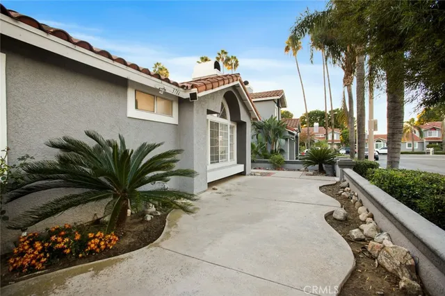 a picture of a house with a yard and potted plants