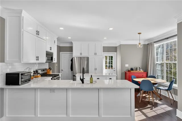 a kitchen with stainless steel appliances kitchen island granite countertop a sink and cabinets