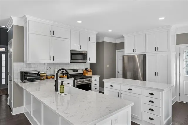 a kitchen with stainless steel appliances a refrigerator sink and microwave
