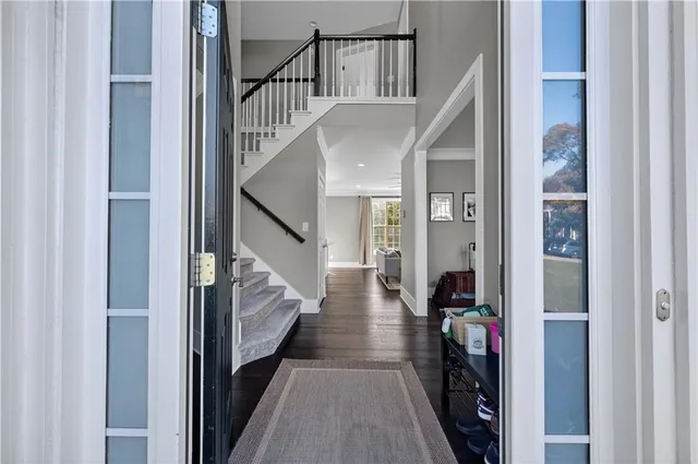 a view of staircase with lots of frames on wall and wooden floor