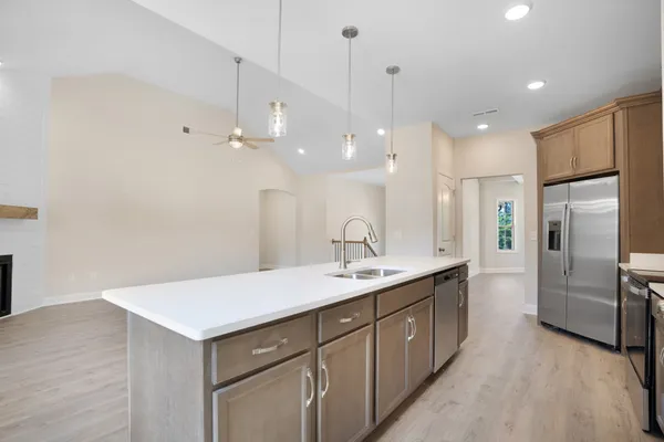 a kitchen with a refrigerator sink and cabinets