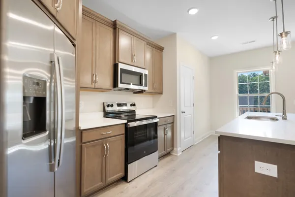 a kitchen with stainless steel appliances granite countertop a stove a sink and a refrigerator