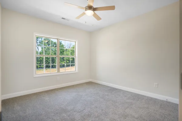 an empty room with a window and a fan