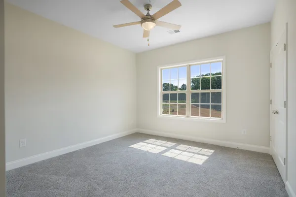 an empty room with a window and a fan