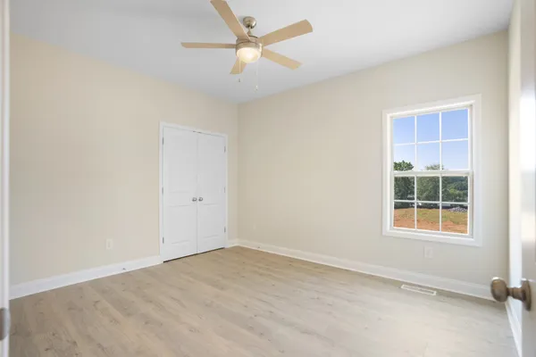 an empty room with a ceiling fan and a window