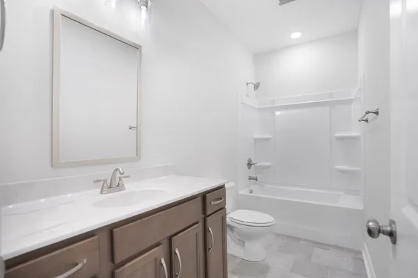 a bathroom with a granite countertop sink a toilet and shower