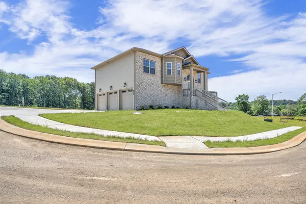a view of a house with a big yard and large tree