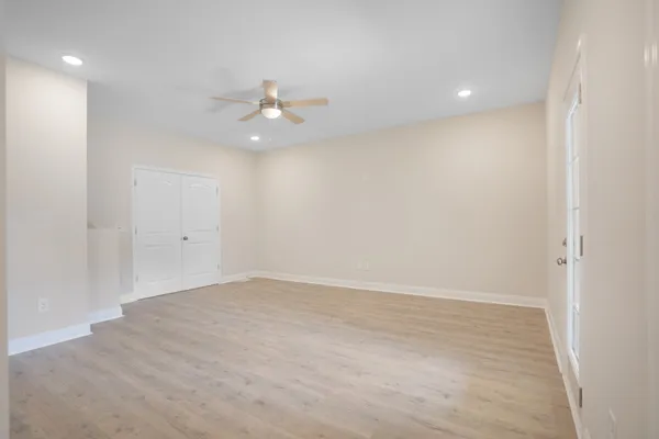 an empty room with a window and ceiling fan