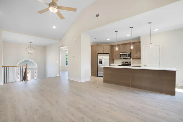 a view of kitchen with kitchen island refrigerator sink and cabinets